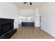 Open-concept living area with a black brick fireplace and light wood-look flooring leading to the kitchen at 3770 Shirebrook Dr # 160, Las Vegas, NV 89115