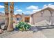 Inviting single-story home with desert landscaping, an arched entryway, and a spacious driveway at 392 Waterwheel Falls Dr, Henderson, NV 89015