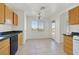 The bright kitchen features tile flooring, wood cabinetry, black appliances and access to the backyard pool at 392 Waterwheel Falls Dr, Henderson, NV 89015