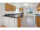 Bright kitchen features tile flooring, wood cabinetry, black countertops and a window offering desert views at 392 Waterwheel Falls Dr, Henderson, NV 89015