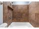 Full tub and shower with dark stone tile at 4000 Visby Ln, Las Vegas, NV 89119