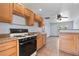 Cozy kitchen features wooden cabinets, black appliances, and tiled floors for easy cleanup at 4000 Visby Ln, Las Vegas, NV 89119