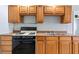 Cozy kitchen features wooden cabinets and black appliances, perfect for meal preparation at 4000 Visby Ln, Las Vegas, NV 89119