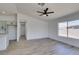 Spacious living room with lots of natural light and wood-look flooring flows into the open kitchen at 4255 Breezy Point Ln, Las Vegas, NV 89115