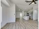 Bright, open-concept living room with modern ceiling fan and wood-look floors flows into kitchen at 4255 Breezy Point Ln, Las Vegas, NV 89115