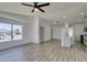 Open concept living room and kitchen with plenty of light and wood-look flooring at 4255 Breezy Point Ln, Las Vegas, NV 89115
