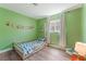 Green bedroom features wood-look floors, a window, and a crib at 508 Purcell Dr, Las Vegas, NV 89107