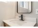Modern bathroom vanity with a rectangular mirror, black faucet and quartz countertops at 5245 Hillman Ave, Las Vegas, NV 89142