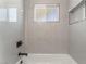 Well-lit bathroom features tile surround, window, and built-in storage niche at 5245 Hillman Ave, Las Vegas, NV 89142