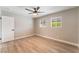 A cozy bedroom features wood floors, a ceiling fan and natural light at 5245 Hillman Ave, Las Vegas, NV 89142