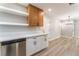 Well-lit kitchen featuring stainless steel dishwasher, quartz countertops and open shelving at 5245 Hillman Ave, Las Vegas, NV 89142