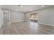 Bright, airy living room featuring modern gray laminate flooring and sliding glass doors to backyard at 5245 Hillman Ave, Las Vegas, NV 89142