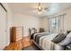 Bedroom with hardwood floors, ceiling fan, large dresser, and natural light at 5401 Bugle Way # 103, Las Vegas, NV 89108