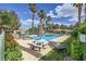 Community pool with picnic tables and lounge chairs amidst mature trees, providing a perfect spot for recreation at 5401 Bugle Way # 103, Las Vegas, NV 89108