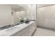 Bright bathroom features a double sink vanity and an expansive glass-enclosed shower with marble-look tile at 6056 Willow Rock St, Las Vegas, NV 89135