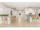 Open-concept living space featuring kitchen with granite island, stainless appliances, and modern lighting fixtures at 6056 Willow Rock St, Las Vegas, NV 89135