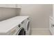 A convenient laundry room with a modern washer and dryer with cabinets above for storage at 6056 Willow Rock St, Las Vegas, NV 89135