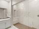 This bathroom features a glass enclosed shower with bench and grey and white marble look tiling at 6056 Willow Rock St, Las Vegas, NV 89135