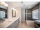 Modern bathroom features dual sinks, large mirrors, and a glass-enclosed shower with bench seating at 6417 Fisher Ave, Las Vegas, NV 89130