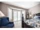 Comfortable bedroom featuring a bay window with shutters, leading to a bright outdoor space and a decorative blue chair at 6417 Fisher Ave, Las Vegas, NV 89130