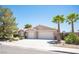 Attractive single-story home with a two-car garage, desert landscaping, and mature palm trees at 6417 Fisher Ave, Las Vegas, NV 89130