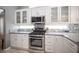 Updated kitchen features stainless steel range, microwave, backsplash, and white cabinets at 6417 Fisher Ave, Las Vegas, NV 89130