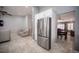 Open living area with tile flooring, ceiling fan, and stainless steel refrigerator in kitchen nearby at 6417 Fisher Ave, Las Vegas, NV 89130