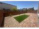A backyard showing synthetic grass, rock landscaping and block wall at 7499 Lodano Ave, Las Vegas, NV 89113
