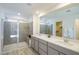 Modern bathroom featuring a glass shower and a double sink vanity with contemporary fixtures and bright lighting at 7499 Lodano Ave, Las Vegas, NV 89113