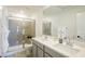 Bathroom featuring a glass shower, double sink vanity with modern fixtures and bright lighting at 7499 Lodano Ave, Las Vegas, NV 89113