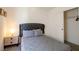 Comfortable bedroom with carpeted floors, neutral walls, closet, window and a side table with lamp at 7499 Lodano Ave, Las Vegas, NV 89113