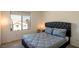 Inviting bedroom with modern lamp, carpet, neutral walls, and a window with a view to the outside at 7499 Lodano Ave, Las Vegas, NV 89113