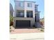 Two-story home featuring a balcony, two-car garage, and brick paved driveway at 7499 Lodano Ave, Las Vegas, NV 89113