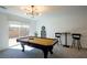 Bright game room with a pool table, bar seating, and access to the outdoor patio at 7499 Lodano Ave, Las Vegas, NV 89113