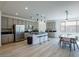 Spacious kitchen featuring an island with bar seating, stainless steel appliances and wood floors at 7499 Lodano Ave, Las Vegas, NV 89113