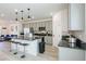 Spacious kitchen featuring an island with bar seating, stainless steel appliances and wood floors at 7499 Lodano Ave, Las Vegas, NV 89113