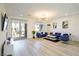 Bright, open-concept living area with modern decor, wood flooring and access to outdoor balcony at 7499 Lodano Ave, Las Vegas, NV 89113