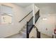 Bright entryway staircase with carpeted steps and dark wood railing leading to the second floor of the home at 7499 Lodano Ave, Las Vegas, NV 89113