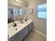 Bathroom featuring double sinks, large mirror, neutral color scheme, and tile flooring at 8340 Winterchase Pl, Las Vegas, NV 89143