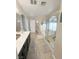 Bathroom featuring dual sinks, a large mirror, and tile flooring leading to the tub and shower at 8340 Winterchase Pl, Las Vegas, NV 89143
