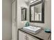Well-lit bathroom featuring a modern vessel sink, dark countertops, and ample storage at 8501 W University Ave # 1083, Las Vegas, NV 89147