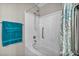 Bathroom featuring a tub with shower and white tiled walls, with turquoise towels at 8501 W University Ave # 1083, Las Vegas, NV 89147