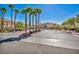 A gated community entrance featuring lush landscaping, towering palm trees, and well-kept grounds at 8501 W University Ave # 1083, Las Vegas, NV 89147