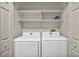 Convenient laundry room featuring a neatly arranged washer and dryer with overhead shelving at 8501 W University Ave # 1083, Las Vegas, NV 89147