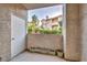 Outdoor patio with a white door, stucco walls, and view of surrounding garden landscaping at 8501 W University Ave # 1083, Las Vegas, NV 89147