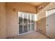 Cozy outdoor patio featuring stucco walls and a sliding glass door with shutter style blinds at 8501 W University Ave # 1083, Las Vegas, NV 89147
