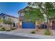 Two-story home featuring a two car garage, stone accents, and mature landscaping at 9327 S Chieftain St, Las Vegas, NV 89178