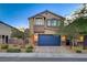 Charming home with a blue garage door, stone accents, and fresh landscaping at 9327 S Chieftain St, Las Vegas, NV 89178