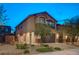 Beautiful home exterior with a red door, blue garage, landscaped front yard, and unique architectural details at 9327 S Chieftain St, Las Vegas, NV 89178