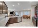 Open concept kitchen and living area with modern stainless steel appliances and granite countertops at 9327 S Chieftain St, Las Vegas, NV 89178